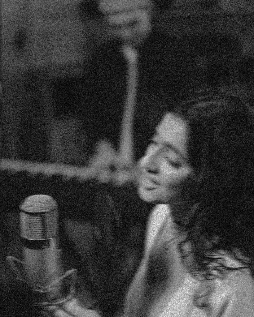A vocalist performing into a studio microphone